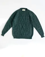 Sweater de lana merino color verde con diseño de trenzas en el frente.