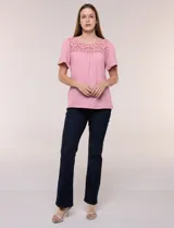 Blusa blanca de textura gofrada, de corte recto y semi holgado, con mangas cortas y escote redondo adornado con un canesú frontal en crochet calado.