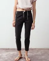 Pantalón cigarette negro confeccionado en tela techno italiana. Tiro medio, cintura elastizada en la espalda, cierre y snap metálico en el delantero, bolsillos laterales con cierre y cierre en la botamanga.