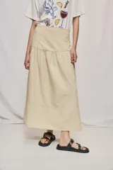 Falda midi de denim color beige, con diseño de volados y caída fluida.