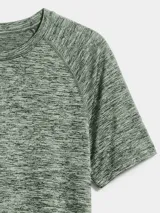 Camiseta deportiva de manga corta con diseño jaspeado, cuello redondo y dobladillo curvo. Presenta un pequeño logo reflectante en la parte inferior.