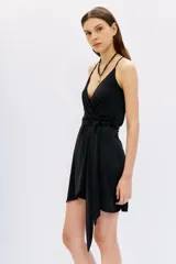 Vestido corto negro ajustado al cuerpo, con escote cruzado en V, breteles finos y lazo ajustable en la cintura.