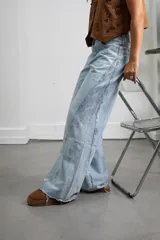 Jean de corte recto y tiro alto con diseño bicolor, presentando un panel lateral en un tono de azul ligeramente más oscuro que el resto de la prenda. Confeccionado en denim de lavado claro.