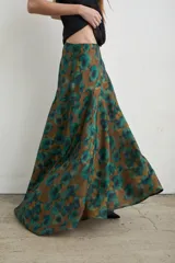 Falda larga irregular de seda con estampado en tonos marrón y verde, corte evasé y caída fluida.