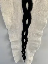 Tapiz decorativo de fieltro artesanal en lana merino uruguaya, con diseño abstracto en blanco y negro.