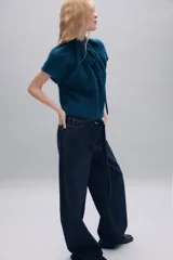 Jersey de punto de textura suave en color azul, con cuello redondo ajustable mediante cordones del mismo tejido y manga corta.