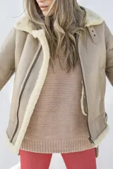 Campera bomber de cuero color beige con cuello y puños de piel sintética color crema.