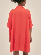 Túnica corta de lino color naranja, con cuello camisero y escote en V. Mangas cortas y corte holgado.