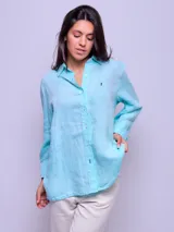 Camisa de lino color celeste, de manga larga, con cierre frontal de botones y cuello camisero.