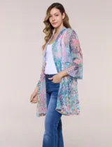Cardigan largo de tul semitransparente color verde, con estampado patchwork y bordados florales en relieve. Presenta diseño de frente abierto con solapas fluidas y mangas tres cuartos acampanadas.