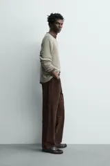 Pantalón de corte straight fit confeccionado en ante de color marrón, con diseño de cinco bolsillos y cierre frontal con cremallera y botón.