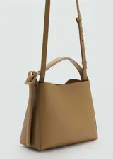 Bolso tipo shopper de tamaño pequeño en color tostado, con diseño estructurado, asa corta ajustable y cierre de imán interior. Incluye una hebilla decorativa lateral y bolsillo interior con cremallera.