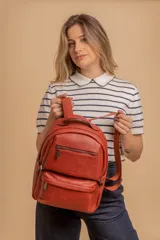 Mochila de cuero sintético color negro con textura granulada. Cuenta con un compartimento principal con cierre, un bolsillo frontal con cierre, correas ajustables y asa superior.