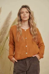 Saco tejido de punto color naranja, con escote redondo, cierre frontal con botones y mangas largas.