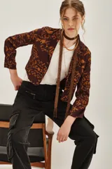 Saco de corte entallado con estampado ikat en tonos marrón y ocre, de manga larga y cierre frontal con botones.