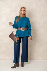 Buzo de punto color azul petróleo, con cuello redondo, mangas largas con puños ajustados y detalles de textura trenzada en la parte superior y el ruedo.