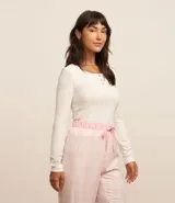 Blusa de pijama con mangas largas, confeccionada en Rib de poliéster con elastano. Prenda posee cuello redondo con botones abajo del cuello además de textura acanalada en todo el tejido.