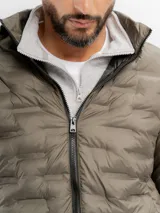 Campera puffer negra con diseño capitoneado, cierre frontal completo y capucha integrada.