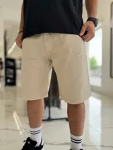 Bermuda baggy de jean color beige, de corte holgado y diseño clásico de cinco bolsillos.