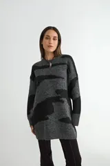 Buzo de tejido de punto con diseño estampado en bloques de color gris y negro, de corte holgado y manga larga.