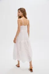 Vestido midi blanco de algodón con diseño broderie, tirantes finos, escote en V y cierre frontal con botones.