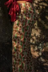 Pantalón de crepé con estampado geométrico en tonos marrón, verde y beige.