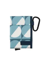 Tarjetero compacto de diseño geométrico en tonos celeste, azul y blanco, con protección RFID, gancho mosquetón metálico lateral y detalle de etiqueta con logo en relieve.