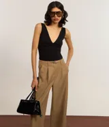 Blusa sin mangas, con frente única confeccionada en bengalina color negro. La prenda tiene escote v y breteles ajustables.