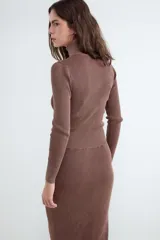 Cardigan de punto en color marrón oscuro, con cuello alto y cierre frontal completo de cremallera.