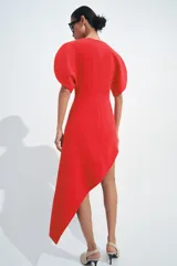 Vestido midi de cuello barco y manga corta abullonada, color rojo, con diseño asimétrico en el bajo en línea evasé y cierre trasero con cremallera oculta.