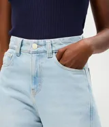 Pantalón de jean con corte new carrot, de cintura alta y estructura firme. Presenta un diseño holgado en la cadera que se estrecha hacia el bajo, con bolsillos funcionales y cierre frontal con botón y cremallera.