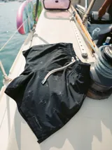 Short de baño negro con estampado sutil de palmeras, cintura elástica con cordón ajustable, bolsillos laterales y trasero. Cuenta con interior de malla hipoalergénica y tejido de secado rápido.