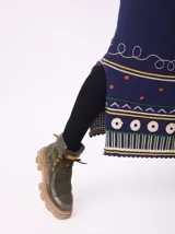 Borcegos de caña baja con diseño robusto, confeccionados en una combinación de gamuza y cuero sintético en tonos verde oliva. Presentan suela track de goma dentada en color suela, cordones al tono con ojalillos amarillos y cuello acolchado para mayor confort.