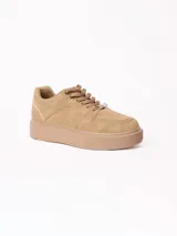 Championes de plataforma color beige, con cordones y suela gruesa de goma texturizada en la puntera.