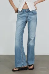 Jeans de tiro bajo con diseño bootcut y acabado flare en el bajo. Cuenta con cinco bolsillos, trabillas para cinturón y cierre frontal con cremallera y botón metálico.