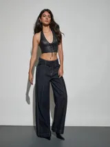 Jean azul oscuro de corte wide leg y tiro alto, con costuras pespunteadas verticales al frente y cinturón incorporado con hebilla cuadrada.