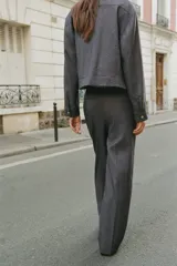 Pantalón de tiro alto con diseño de pernera recta y pinzas delanteras. Cuenta con bolsillos frontales, falsos bolsillos de vivo en la parte trasera y cierre frontal con cremallera, botón interior y gancho.