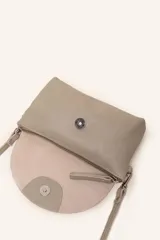 Cartera bandolera color beige, confeccionada en 100% cuero, con solapa redondeada, detalle de flor grabada y correa larga ajustable.