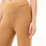Pantalón de playa de punto croché color marrón tostado, de corte recto y holgado, ideal para usar sobre el traje de baño.