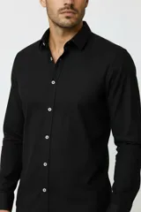 Camisa de viscosa color negro, de manga larga, con cuello camisero y cierre frontal de botones.