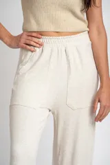 Pantalón de corte recto y holgado, confeccionado en tejido liviano color arena con textura jaspeada. Presenta cintura elástica con cordón interno, bolsillos frontales tipo parche y un calce fluido.