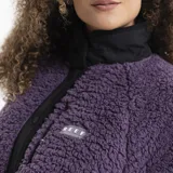 Campera de polar tipo corderito en color violeta, con cuello alto, cierre frontal con botones a presión y detalles en negro. Cuenta con un bolsillo frontal con cierre y logo de la marca.