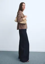 Pantalón de jean tiro alto con corte culotte y pernera ancha. Presenta cierre frontal con cremallera y botón, trabillas para cinturón, bolsillos traseros y bajo con acabado deshilachado.