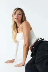 Top asimétrico de una sola manga larga, color azul, con jaretas ajustables en ambos laterales del torso que permiten regular el largo de la prenda.