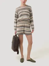 Short de tejido de punto con diseño de rayas horizontales irregulares en tonos tierra, beige y blanco. Presenta cintura elástica y terminación con borde festoneado.