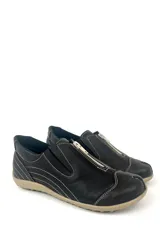 Zapato bajo de cuero negro con cierre frontal con cremallera plateada y costuras decorativas en hilo blanco.