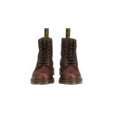 Botas de cuero marrón Dr. Martens 1460 con cordones negros, costuras amarillas características y suela de goma con cámara de aire. Cuentan con forro interior de piel sintética y tirador trasero con el logo de la marca.