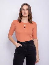 Remera color salmón de manga corta con aberturas circulares en el escote y textura acanalada.
