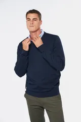 Suéter de tejido fino color azul marino, con cuello en V y manga larga. Presenta un pequeño logo bordado en el pecho.