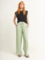 Pantalón de lino color lila, tiro alto, corte palazzo con elástico en la pretina, bolsillos laterales y dobladillo invisible.